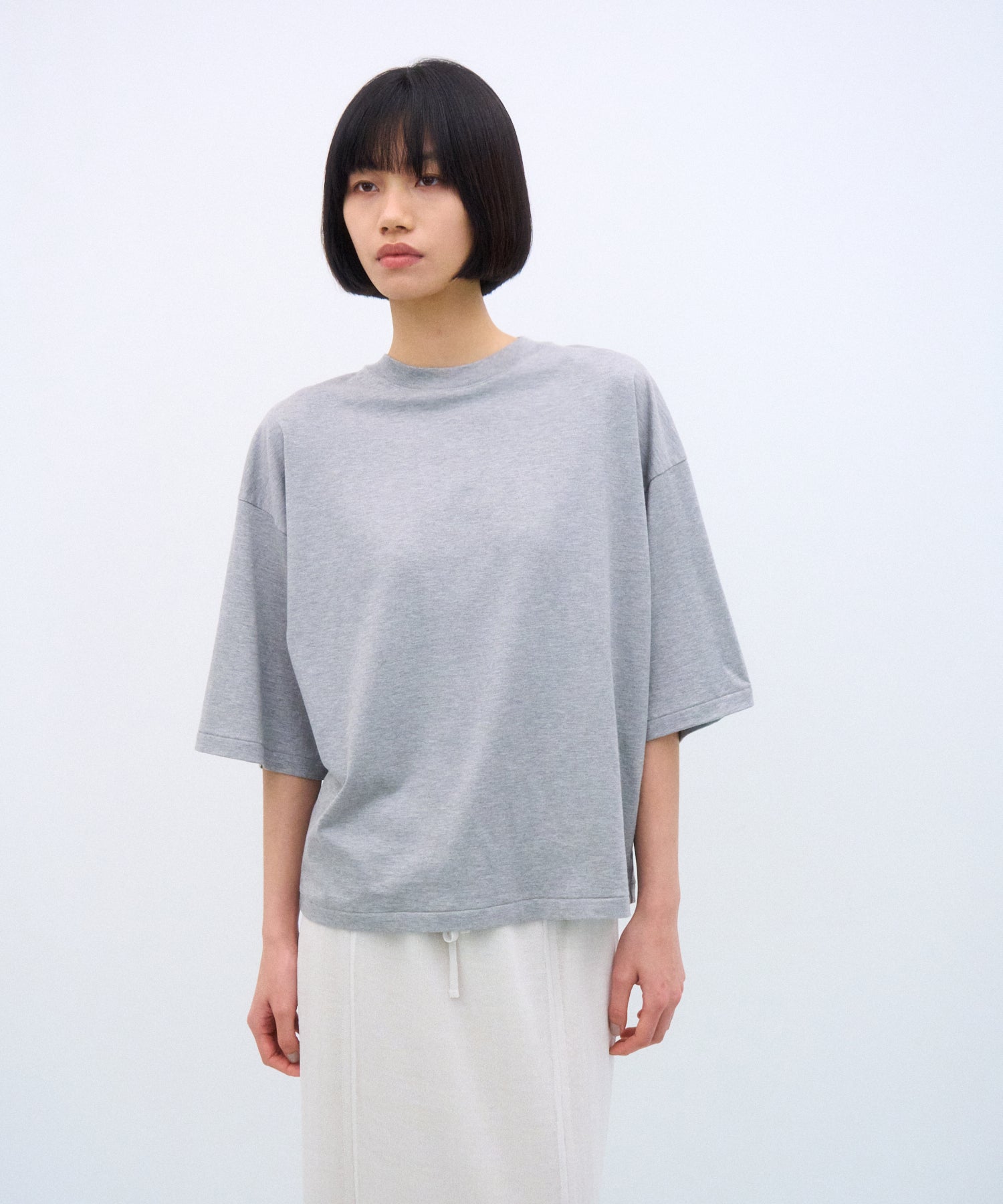 ATON スビンコットンのワイドスリーブTシャツを着た人物